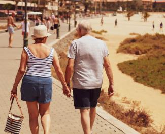 man and woman walking on road while holding hands by Sam Williams courtesy of Unsplash.