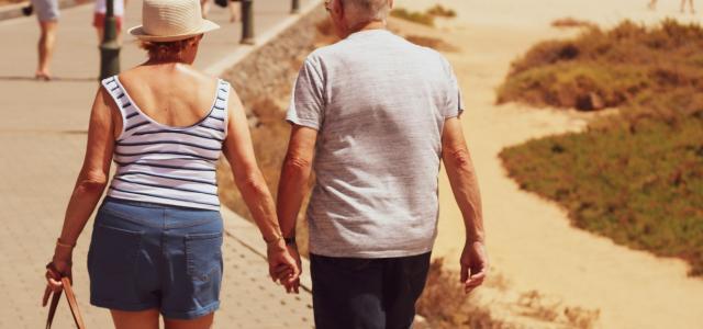 man and woman walking on road while holding hands by Sam Williams courtesy of Unsplash.